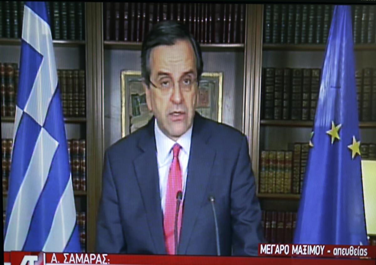 In this image taken from State TV, Greece's Prime Minister Antonis Samaras remarks on the bond sale from his office in Athens.