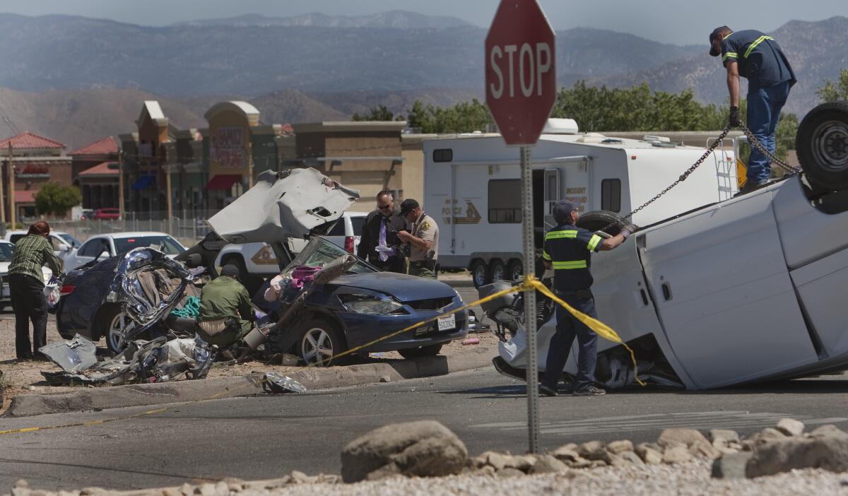 Hesperia police and the San Bernardino County Sheriff's Department investigate the scene where five people were killed inside a Honda on May 11, 2014.