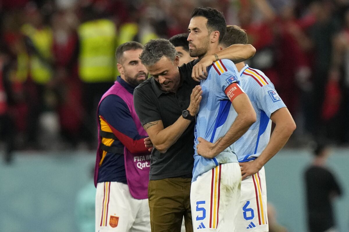 Spain's head coach Luis Enrique, left, embraces Sergio Busquets after the penalty shootout at the World Cup round of 16 soccer match between Morocco and Spain, at the Education City Stadium in Al Rayyan, Qatar, Tuesday, Dec. 6, 2022. (AP Photo/Luca Bruno)
