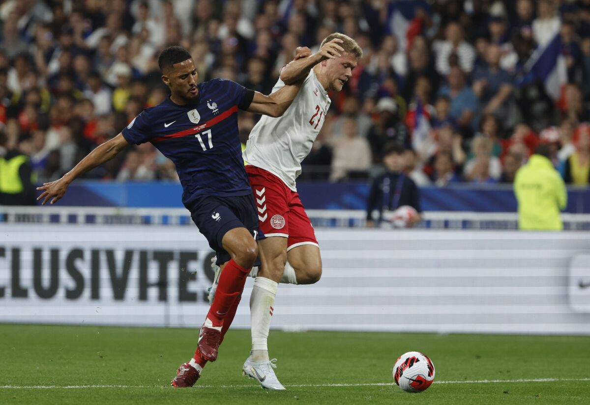 Denmark's Andreas Cornelius, right, challenges for the ball with France's William Saliba during the UEFA Nations League soccer match between France and Denmark at the Stade de France in Saint Denis near Paris, France, Friday, June 3, 2022. (AP Photo/Jean-Francois Badias)
