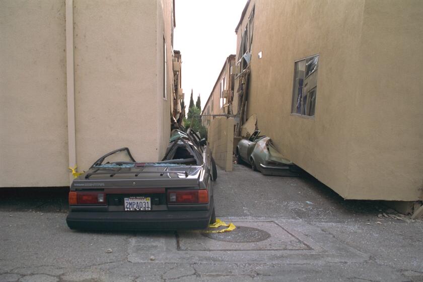 A building with a weak first story collapses on cars during the Northridge earthquake of 1994.