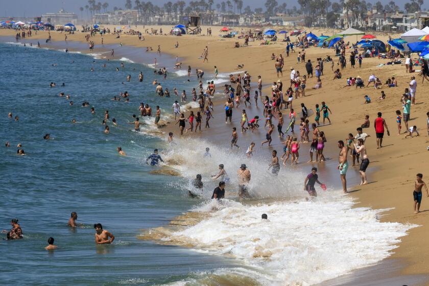 NEWPORT BEACH, CA., SEPTEMBER 2, 2019: Waves crash into shore and those seeking refuge from the heat on the beach north of the Balboa Pier on Labor Day September 2, 2019 (Mark Boster For the LA Times).
