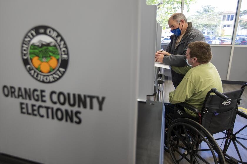 Burgess Norminton and his son Cole cast their ballot during a special election for an open seat on the Orange County Board of Supervisor's District 2 on Tuesday, March 9 at Costa Mesa City Hall.