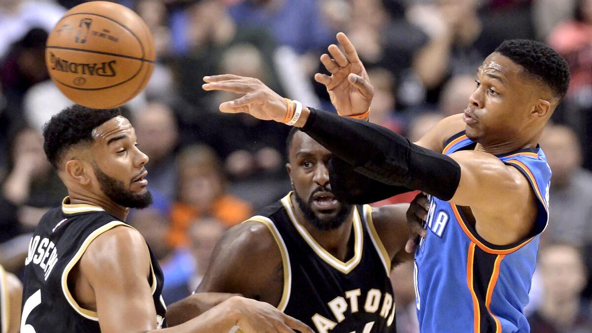 Thunder guard Russell Westbrook makes a pass after Raptors guard Cory Joseph (6) and forward Patrick Patterson cut off is drive during the first half Thursday.