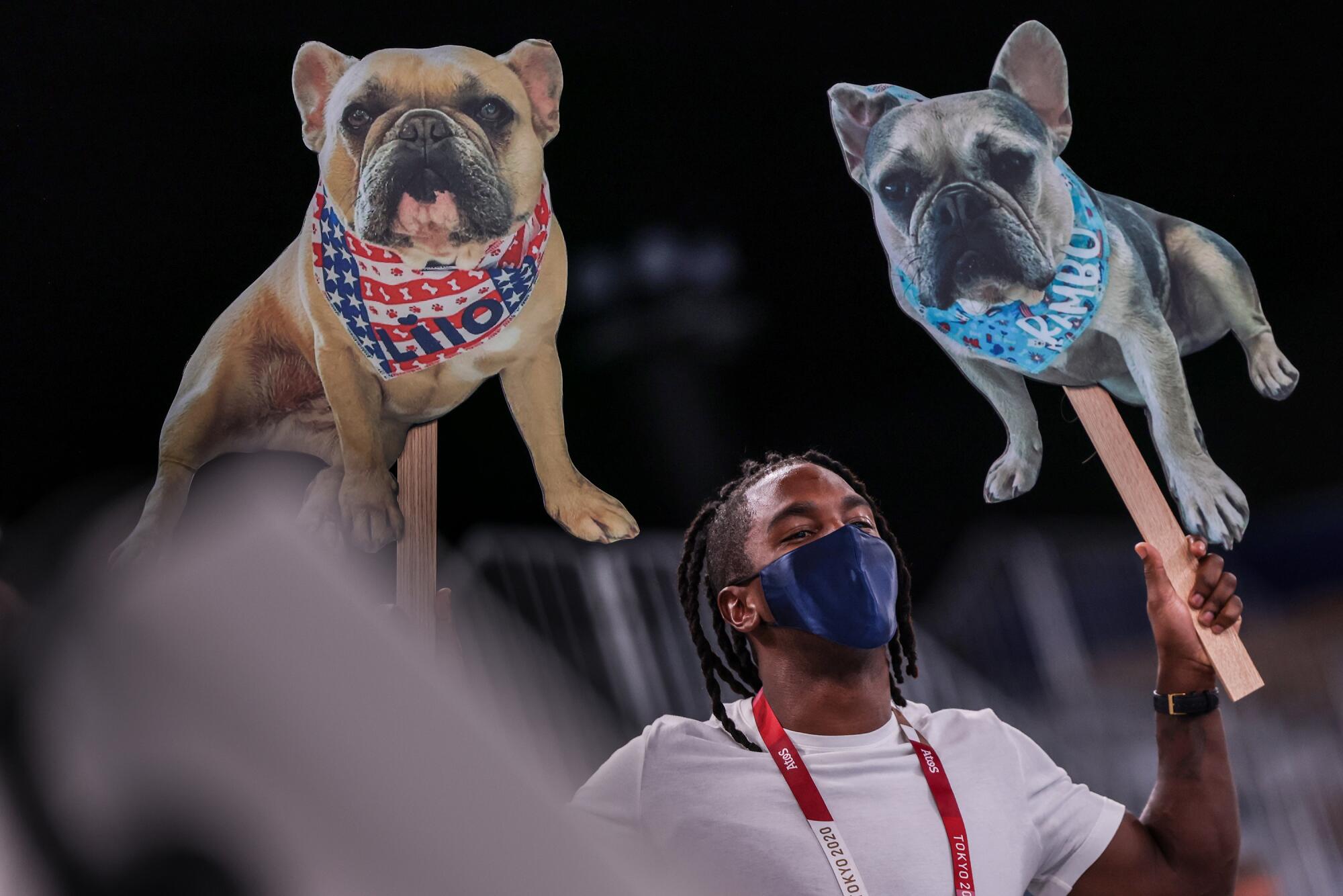 Cardboard cutouts of Simone Bile's dogs, Lilo, left, and Rambo greet her from the stands