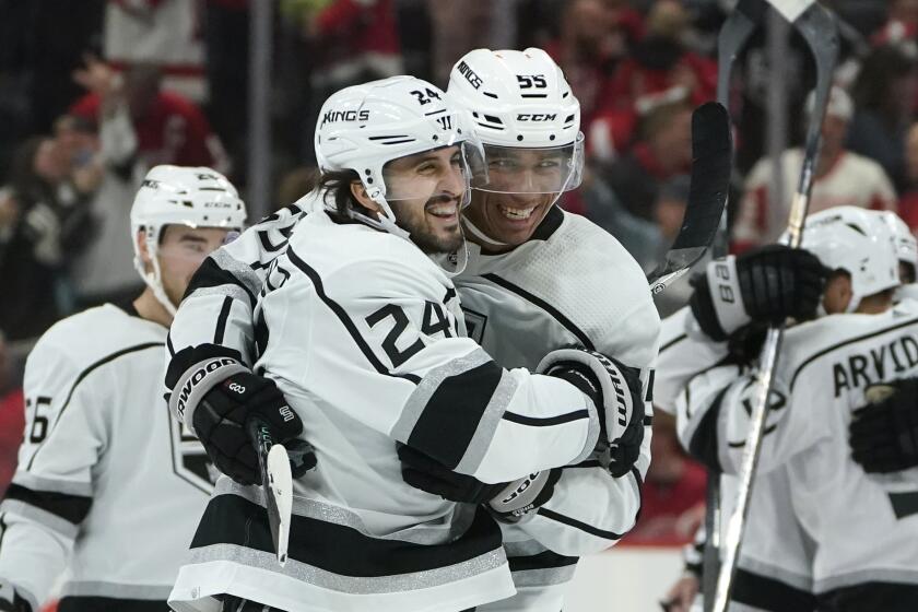 Los Angeles Kings center Phillip Danault (24) celebrates his game winning goal during overtime with Quinton Byfield (55) after an NHL hockey game against the Detroit Red Wings Monday, Oct. 17, 2022, in Detroit. The Kings won 5-4. (AP Photo/Paul Sancya)