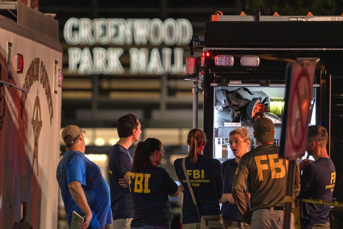 FBI agents gather at the scene of a deadly shooting at a mall.