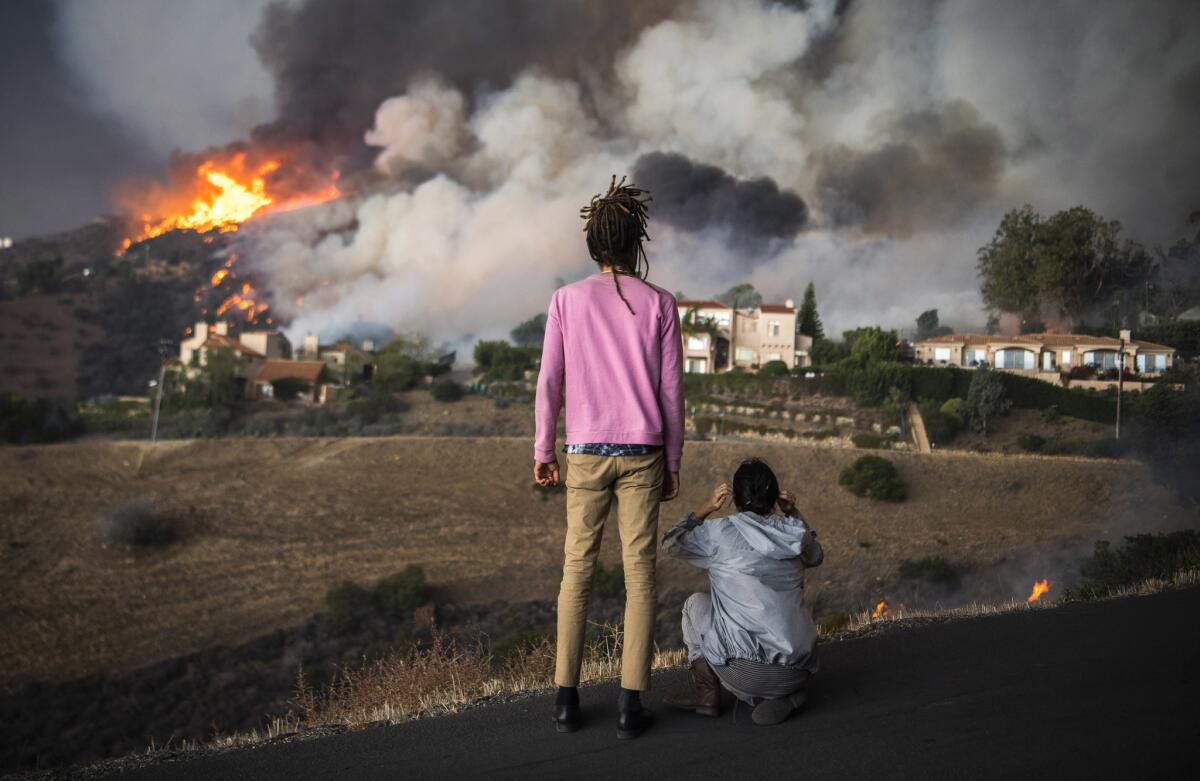 Residents with a home on Las Trancas Canyon Road watch as the Woolsey fire approaches their home in Malibu.