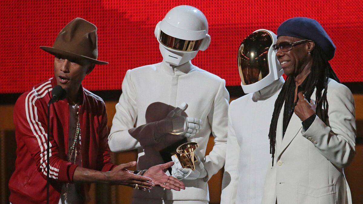 Pharrnell Williams, left, Daft Punk and Nile Rodgers on stage to accept the Grammy for Record of the Year at the 56th Grammy Awards.
