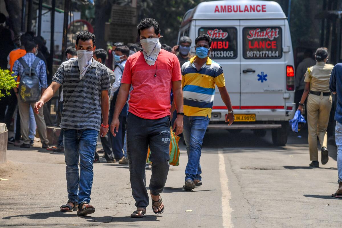 People leave a Mumbai, India, hospital that is treating coronavirus patients on March 17.