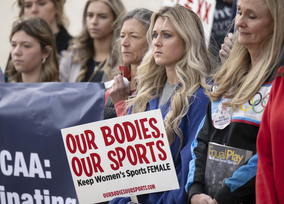 Former Kentucky swimmer Riley Gaines, second from right, stands during a rally.