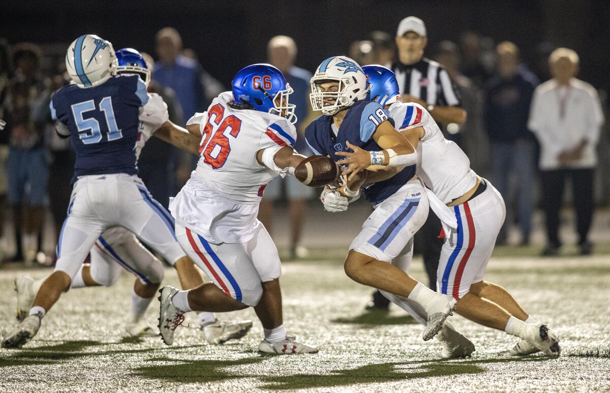 Corona del Mar's David Rasor is sacked by Los Alamitos' Sinn Brennan during a Sunset League game at Davidson Field.