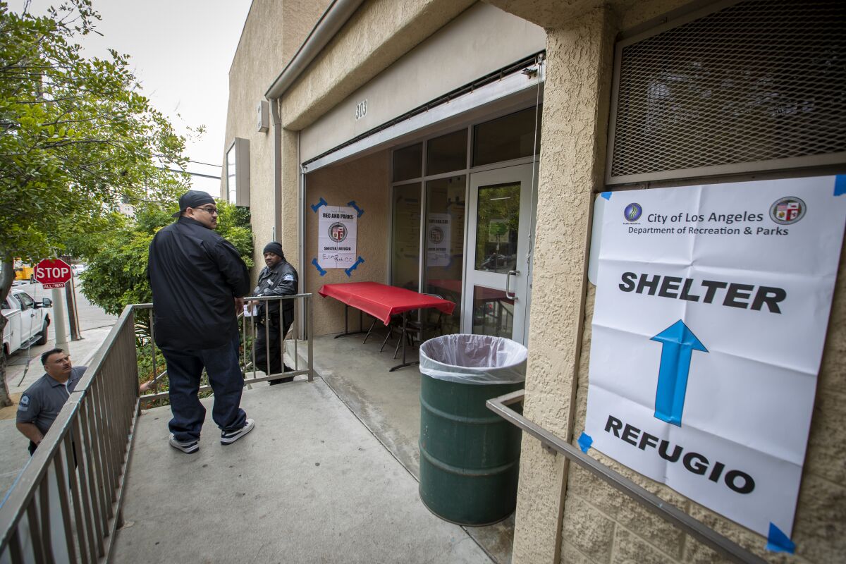 Security guards outside the Echo Park Community Center, one of many area recreation centers that have become temporary shelters for homeless people due to the growing coronavirus pandemic.