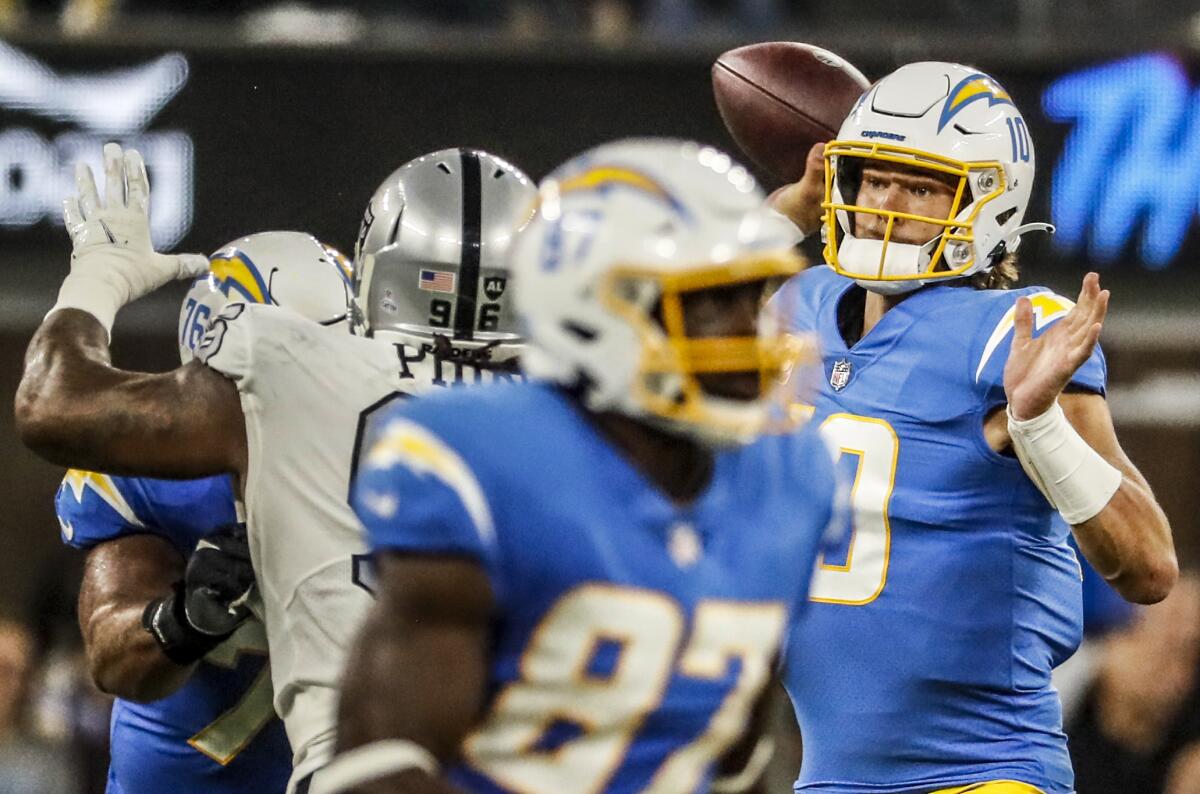 Chargers quarterback Justin Herbert passes under pressure by Las Vegas Raiders defensive tackle Darius Philon.