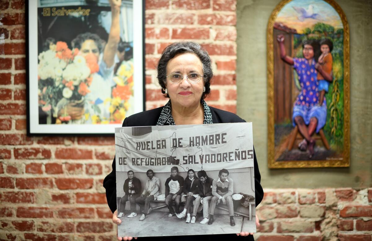 Angela Sanbrano, Chair of CARECEN, Central American Resource Center, holds a photograph of refugees from El Salvador staging a hunger strike calling for refugee status in 1979 in L.A. At the time, Sanbrano was a law student and joined the refugees in solidarity for their cause.