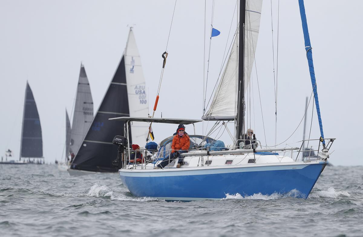 A crew member prepares for the start of the 73rd Newport to Ensenada International Yacht Race off the Balboa Pier on Friday.