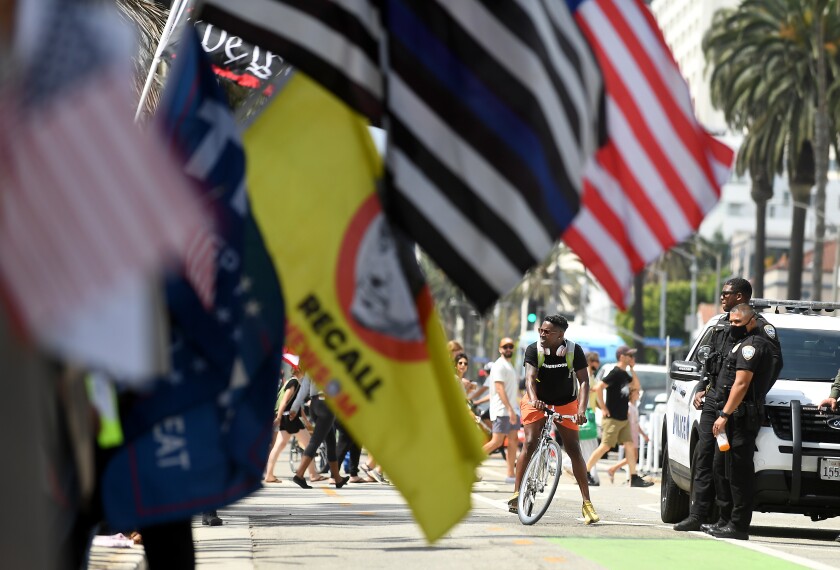 Bicyclists ride by a rally near the Santa Monica Pier for a "worldwide rally for freedom" Sunday.