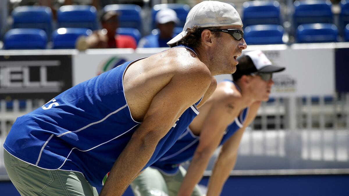 John Hyden, left, and teammate Tri Bourne wait to receive a serve during the World Series of Beach Volleyball tournament in July.