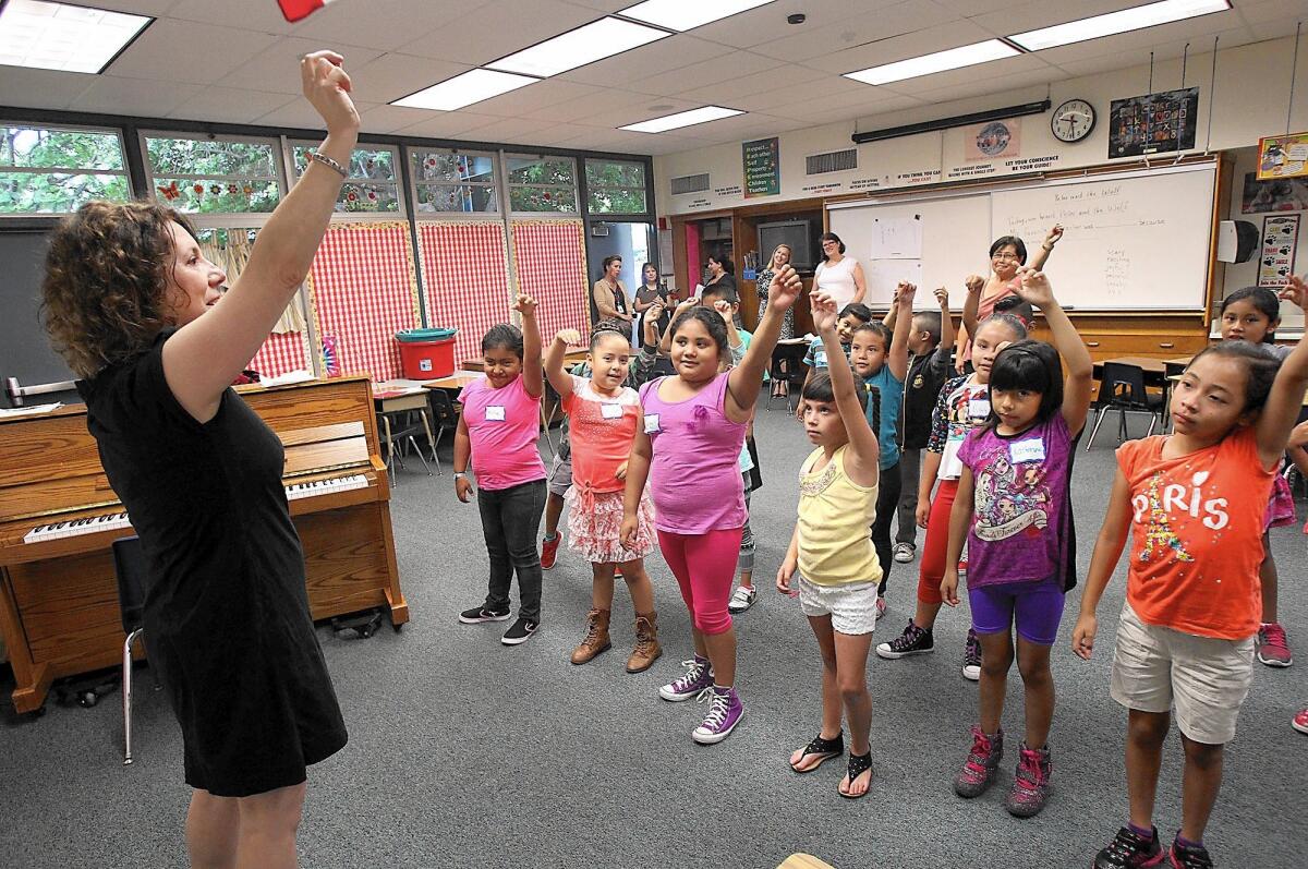 Music teacher Beth Sussman, left, guides kids through Peter and the Wolf number during the Segerstrom Center for the Arts summer classes for young English language learners in the Saddleback Valley Unified School District in Lake Forest on Wednesday.