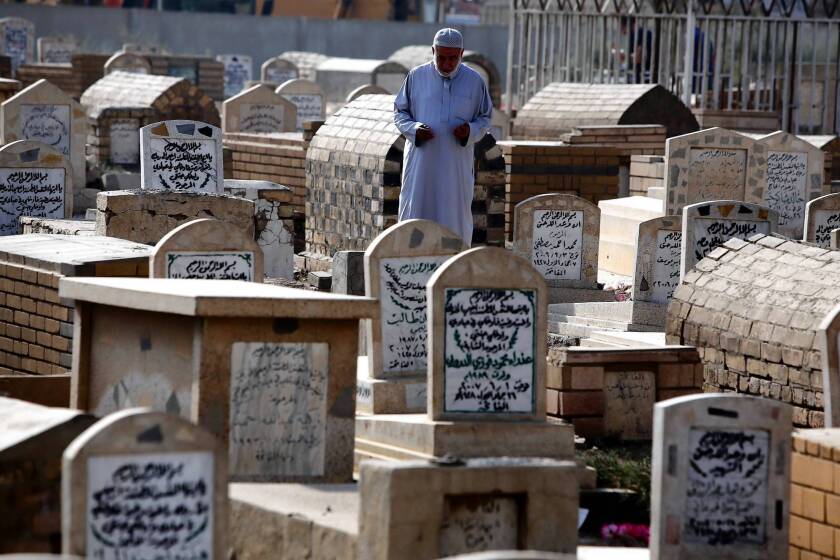 An Iraqi visits a relative's grave in Baghdad for the Eid al-Adha holiday. A new study estimates that nearly half a million Iraqis died as a result of the Iraq war.