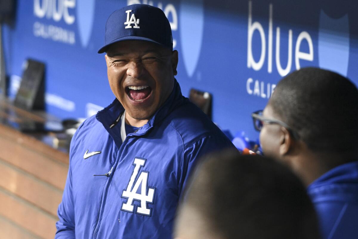 Dodgers manager Dave Roberts laughs in the dugout during a game against the New York Mets in April.