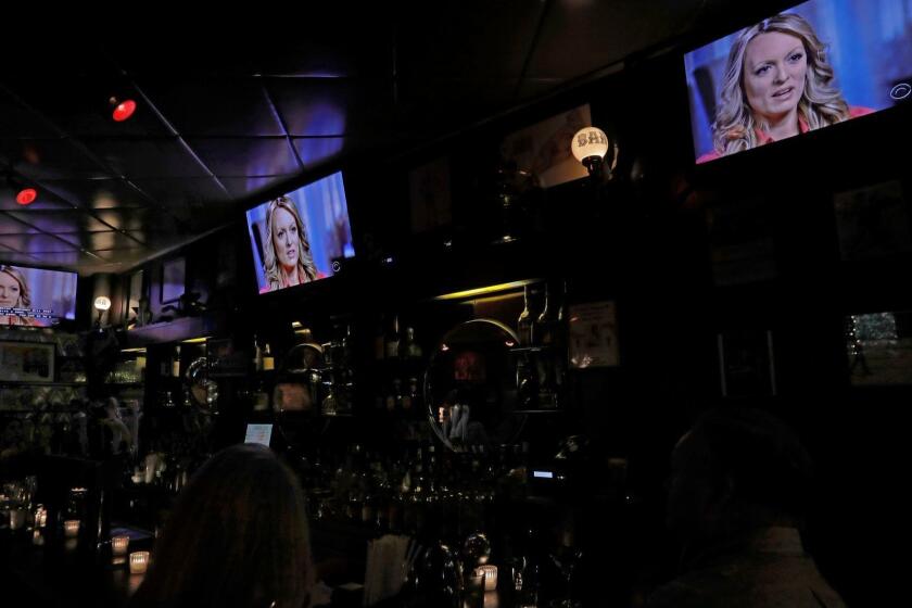 Mandatory Credit: Photo by PETER FOLEY/EPA-EFE/REX/Shutterstock (9476273f) Stephanie Clifford, professionally known as Stormy Daniels, a US adult film actress and director, is seen on screens at the Hi life bar on the upper west side being interviewed on the television show 60 Minutes, in New York, New York, USA, 25 March 2018. Daniels allegedly had a sexual encounter in 2006 with US Presidnent Donald J. Trump. People view adult film star Stormy Daniels interviewed on CBS 60 Minutes, New York, USA - 25 Mar 2018 ** Usable by LA, CT and MoD ONLY **