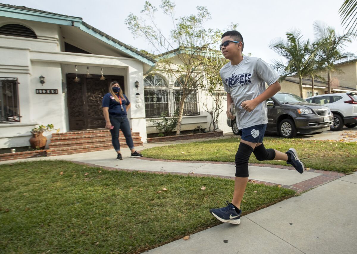 Nathan Rodarte does a 10-minute warmup exercise outside of his home in Lynwood.