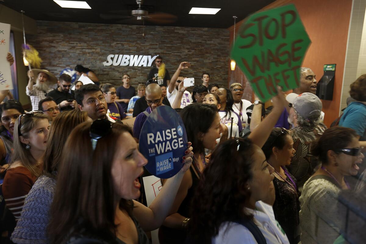 During a break in a planned march, dozens of people crowd a Subway restaurant in Long Beach in September chanting for a higher minumum wage.