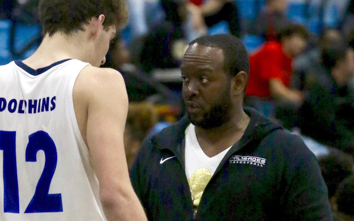 Palisades coach Donzell Hayes talks to forward Caden Arnold.