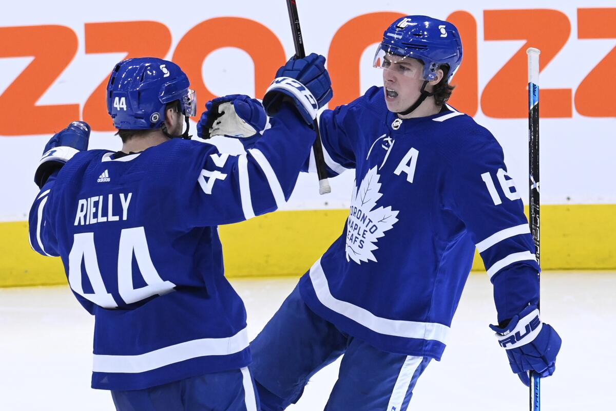 Toronto Maple Leafs center Mitchell Marner (16) celebrates his goal against the Winnipeg Jets with teammate Morgan Rielly (44) during the second period of an NHL hockey game, Thursday, March 11, 2021 in Toronto. (Frank Gunn/The Canadian Press via AP)