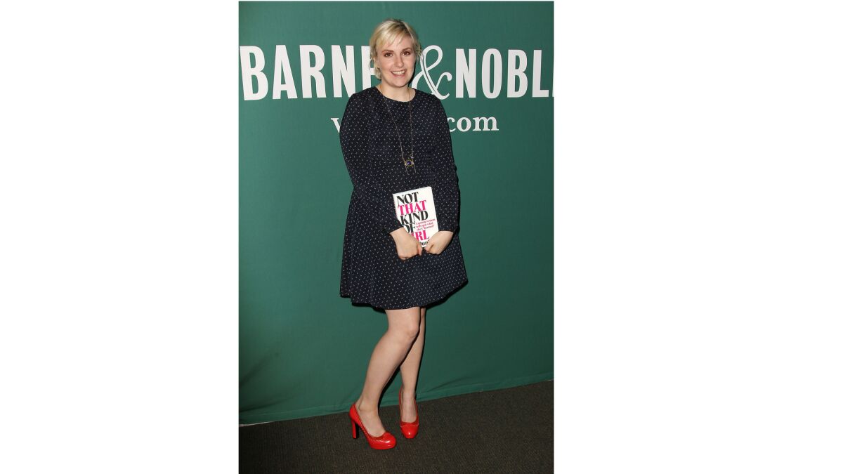 Actress and author Lena Dunham poses with her book, "Not That Kind of Girl: A Young Woman Tells You What She's 'Learned,'" at a book signing in New York.