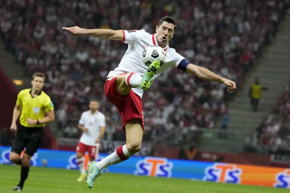 FILE - Poland's Robert Lewandowski controls the ball during the World Cup 2022 group I qualifying soccer match between Poland and England, at the Narodowy stadium in Warsaw, Wednesday, Sept. 8, 2021. Poland captain Robert Lewandowski will shoulder his country’s World Cup hopes as the star name in coach Czesław Michniewicz’ 26-player squad for the tournament in Qatar. Michniewicz, formerly coach of Poland’s under-21s then Legia Warsaw, named his team on Thursday, Nov. 10, 2022. (AP Photo/Czarek Sokolowski, File)