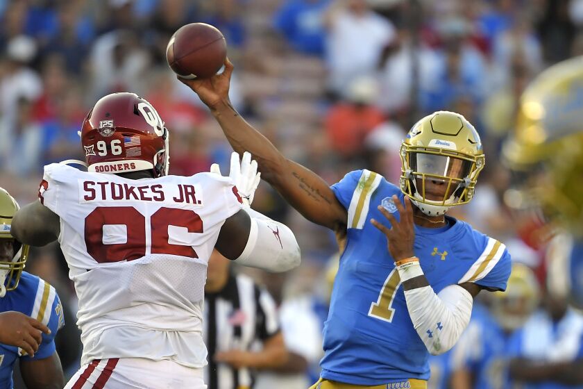 UCLA quarterback Dorian Thompson-Robinson, right, passes while under pressure from Oklahoma defensive lineman LaRon Stokes during the first half of an NCAA college football game Saturday, Sept. 14, 2019, in Pasadena, Calif. (AP Photo/Mark J. Terrill)