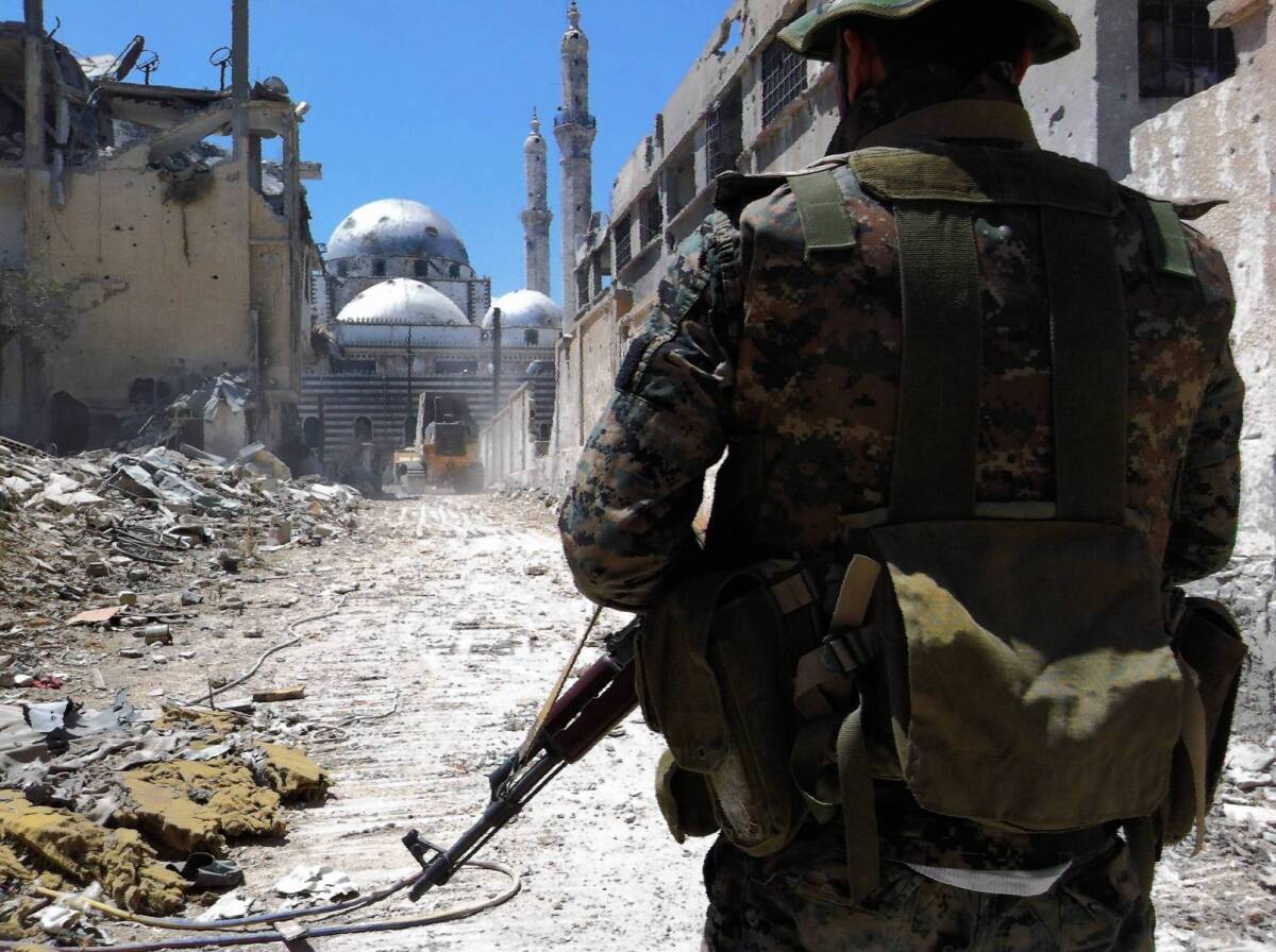 A Syrian soldier stands in front of the Khalid bin Walid mosque in the war-torn Khalidiya neighborhood of Homs.