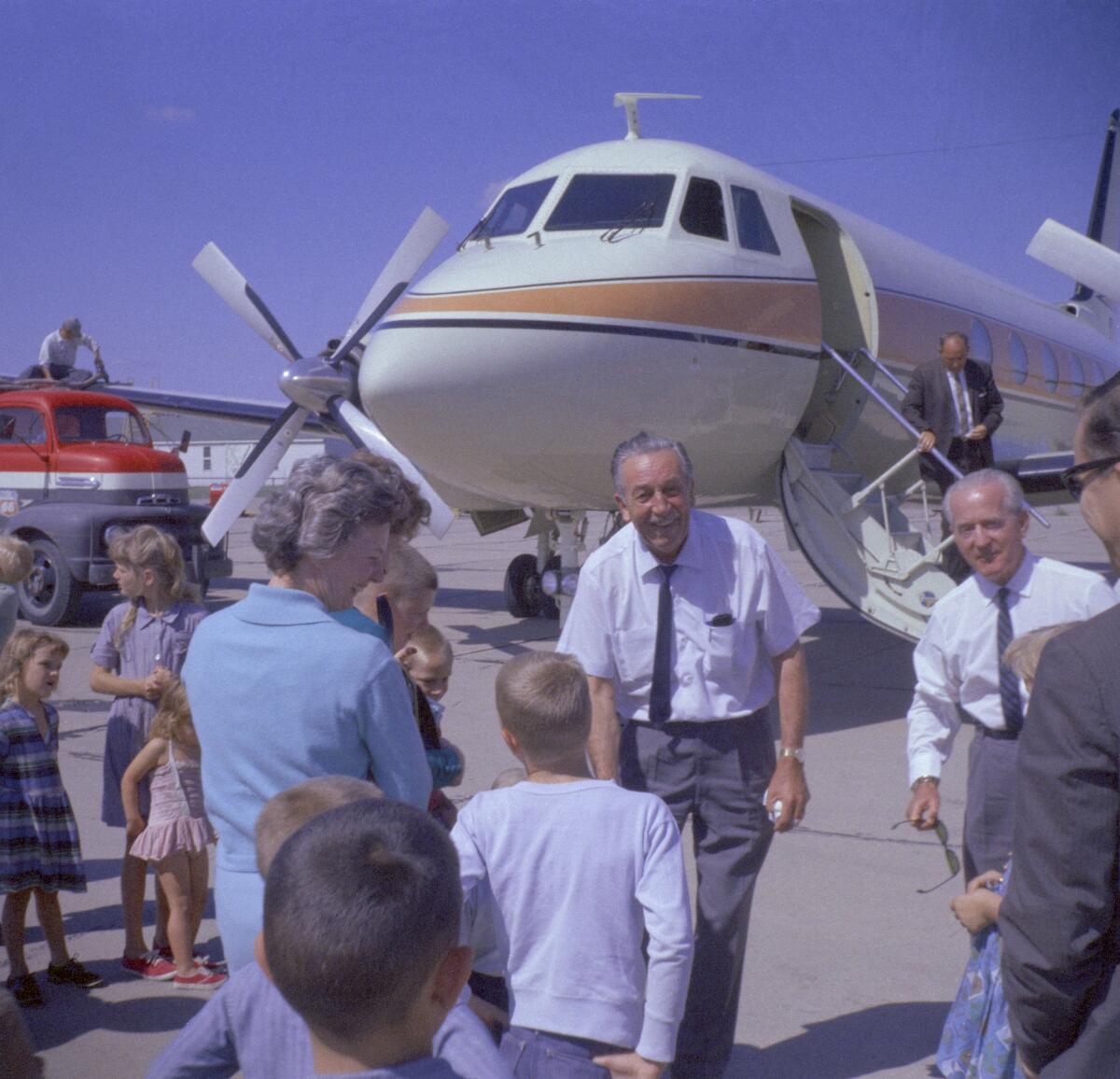 An image of Walt Disney in front of his Grumman Gulfstream I plane shared by Disney.