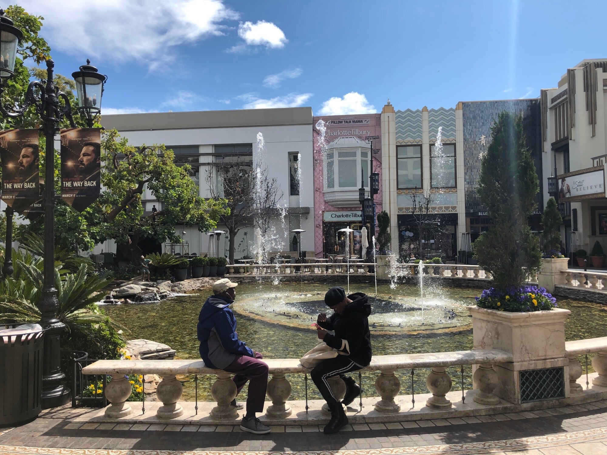 Patrons sit in front of a fountain.