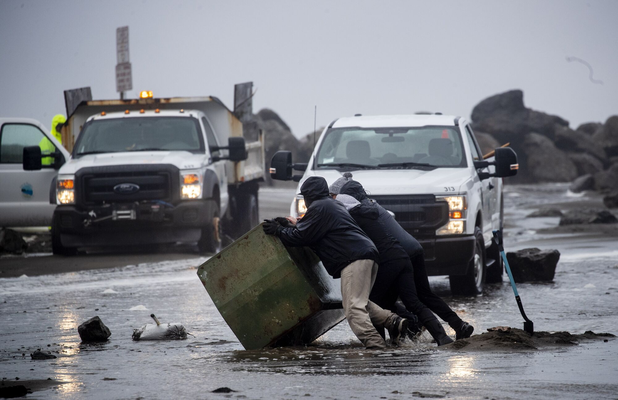 Work crews clear debris from flooded Clarendon Road in Pacifica, California on Thursday.