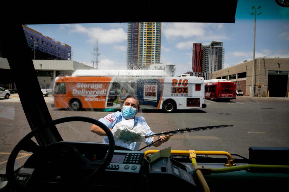 Christopher Castor cleans the windshield of the Route 7 bus he drives through San Diego's City Heights neighborhood.