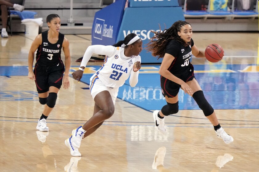 Stanford guard Haley Jones, right, dribbles next to UCLA forward Michaela Onyenwere.