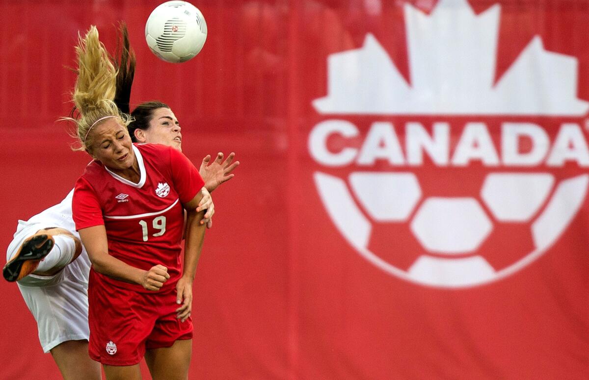 Canada's Adrianna Leon (front) and England's Claire Rafferty collide as they attempt to head the ball during an exhibition game on May 29 in Hamilton, Canada.