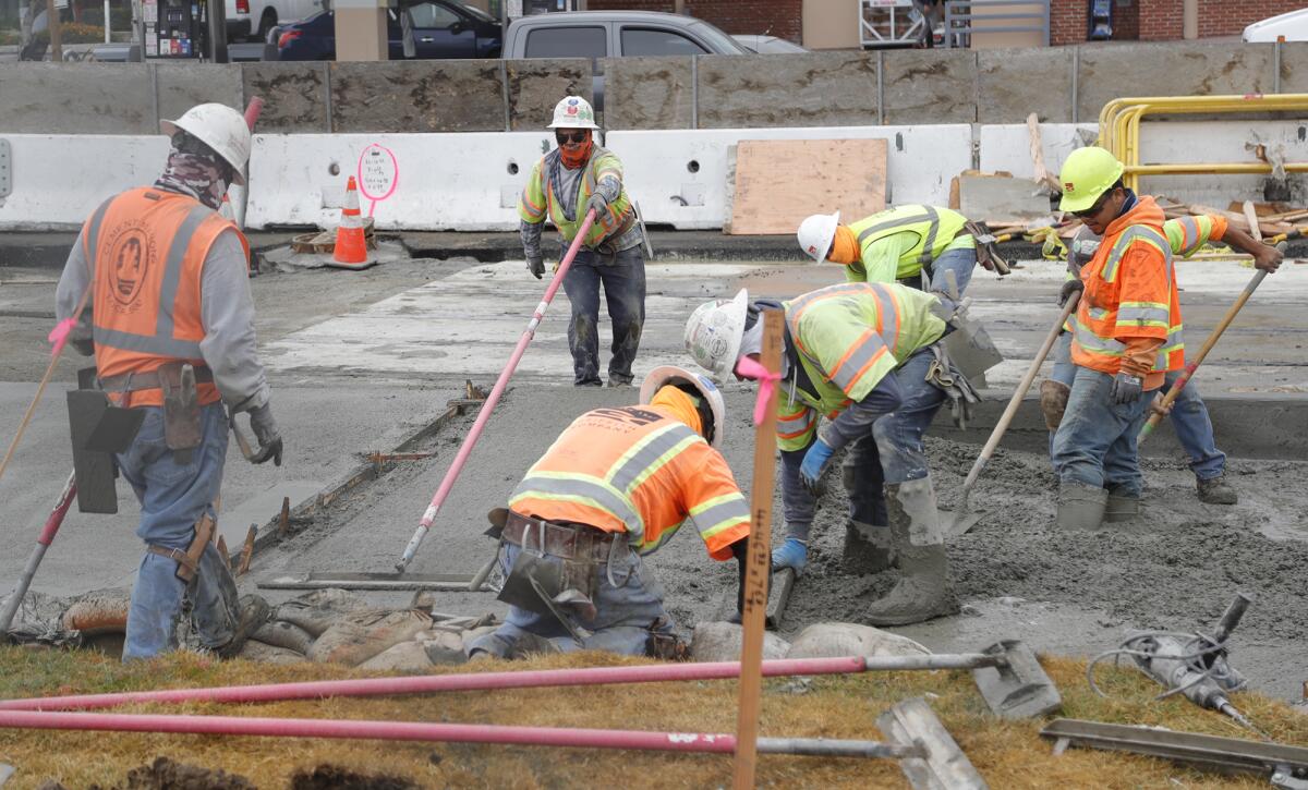 Workers pour cement Monday on Coast Highway in Laguna Beach as part of the $3.6 million Laguna Culvert Replacement project.