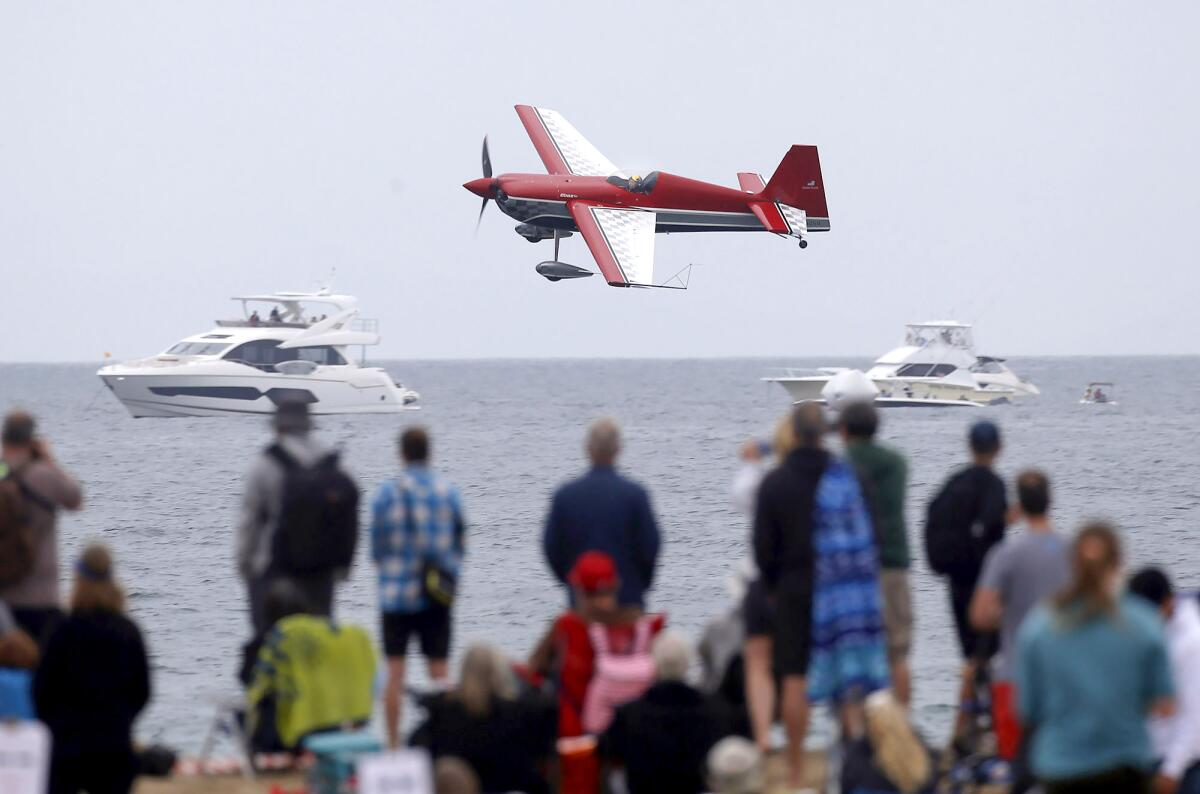 A pilot in his Edge 450 stunt plane flies just above the water on day one of the Pacific Airshow on Friday.