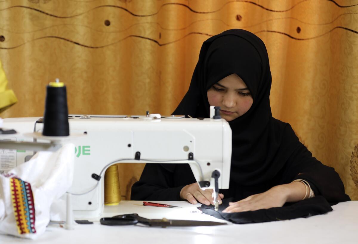 An Afghan woman works with a sewing machine.