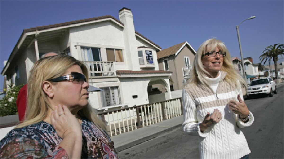 Long-time West Newport residents, Cindy Koller and Lori Morris, stand in front of house they say is one of five rehab facilities that exist on one block off 39th street in Newport Beach.