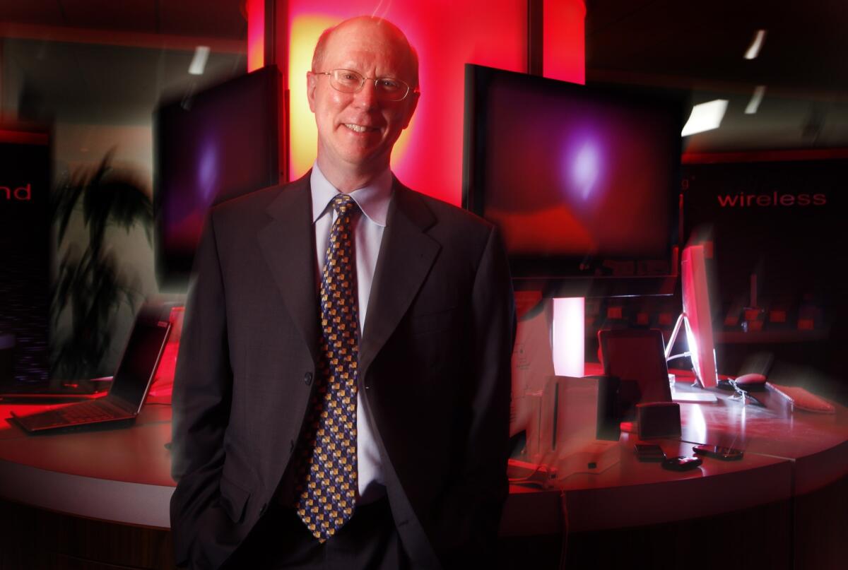 Broadcom Chief Executive Scott McGregor stands near some of the many digital products that use the chips designed and produced by his company in Irvine.