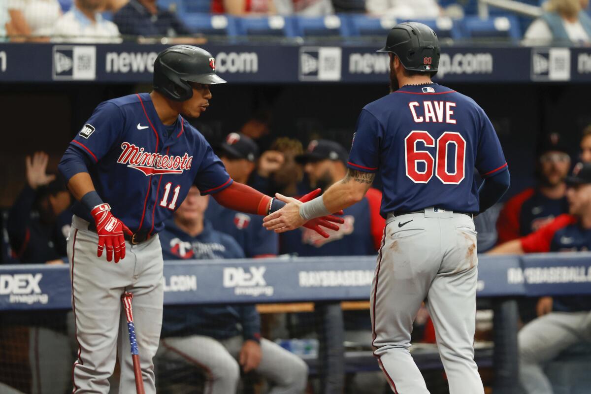 Minnesota Twins' Jake Cave (60) celebrates with teammate Jorge Polanco after scoring against the Tampa Bay Rays during the second inning of a baseball game on Sunday, Sept. 5, 2021, in St. Petersburg, Fla. (AP Photo/Scott Audette)