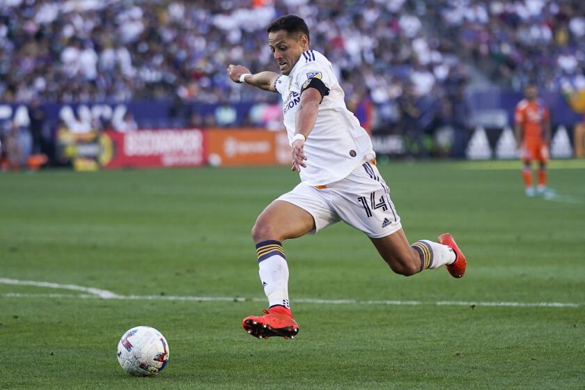 Los Angeles Galaxy's Javier Hernandez dribbles the ball toward the net to score.