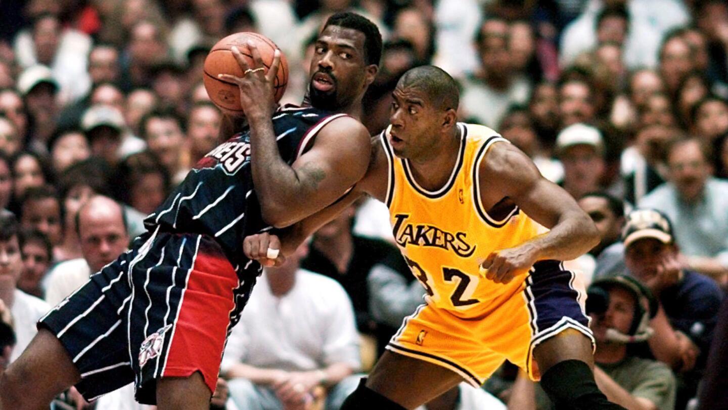 Lakers star Magic Johnson, right, guards the Houston Rockets' Mark Bryant during a game at the Forum on April 25, 1996.