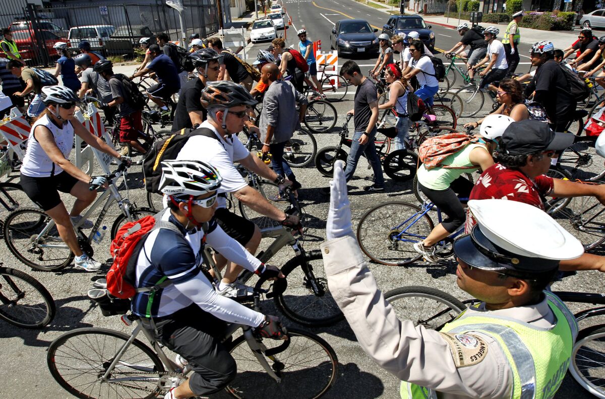 A traffic officer directs bicyclists on Venice Boulevard during a CicLAvia event in 2013. An audit released Wednesday found the Transportation Department had not been reimbursed for $1.8 million in overtime from special events.