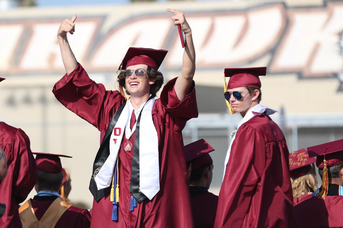 Responding to family cheer, a graduate enters the stadium to the Ocean View High graduation ceremony on Wednesday.